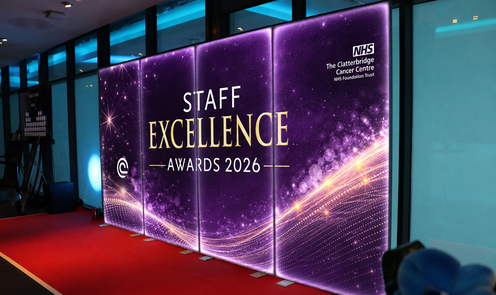 Illuminated purple and gold Staff Excellence Awards 2026 backdrop, Clatterbridge Cancer Centre NHS Foundation Trust